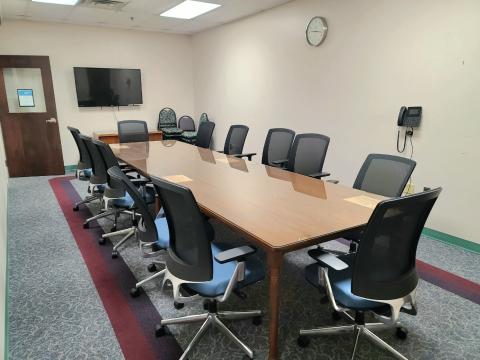 A long conference table with 12 executive-style chairs.